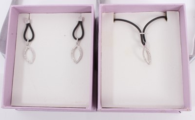 Lot 487 - Diamond pendant and matching earrings with leaf design in 10k white gold setting on black rubber, estimated total diamond weight 0.48cts.