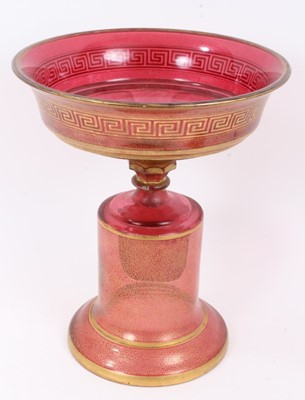 Lot 152 - A late 19th century Bohemian cranberry glass centrepiece, the circular bowl with gilt Greek Key pattern, above a pedestal base with gilt patterns and oval painted portrait of a young woman, 33.5cm...