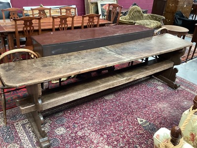 Lot 1370 - Highly unusual ecclesiastical oak refectory table/monks bench, probably 17th century, with massive single plank top raised on shaped trestle ends united by a substantial foot stretcher, 275 x 54cm