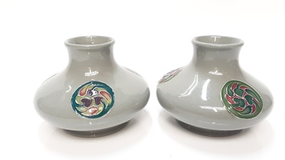 Lot 1123 - Pair of Moorcroft pottery squat vases each with three circular motifs on grey ground, 8cm high
