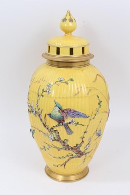 Lot 210 - Continental yellow ground vase with raised polychrome painted bird and flower decoration. Sunburst 584 mark on underside