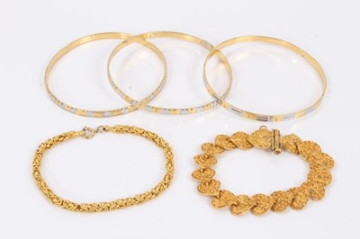 Lot 354 - Three yellow and white metal bangles and two yellow metal bracelets