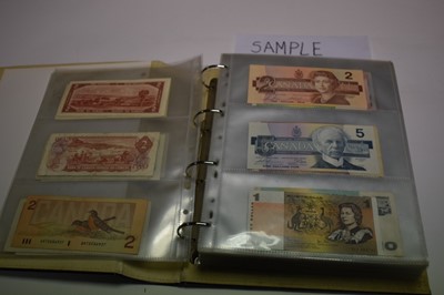 Lot 516 - World - An album containing mixed banknotes to include issues from New Zealand, Canada, East Caribbean, Jamaica, Trinidad & Tobago, Bahamas, India, Guyana, Hong Kong, China, Japan, Belize, Suriname...