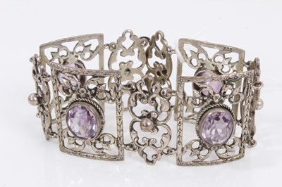 Lot 365 - Dutch silver (800) open work scroll panel bracelet set with four oval mixed cut amethysts, 19cm long