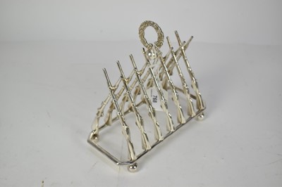 Lot 768 - Impressive early 20th century novelty silver plated six division toast rack in the form of crossed guns, with central laurel leaf wreath, marked Superior S.P. Co, 19.5cm in length.