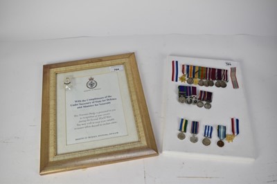 Lot 764 - Collection of miniature medal groups, mounted on a canvas backing, together with a Ministry of Defence Veterans badge and associated paperwork in glazed frame.