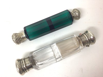 Lot 325 - Victorian Bristol green glass double ended scent bottle with white metal tops, together with a clear glass double ended scent bottle, bearing makers mark to white metal mounts for George Brace. (2)...