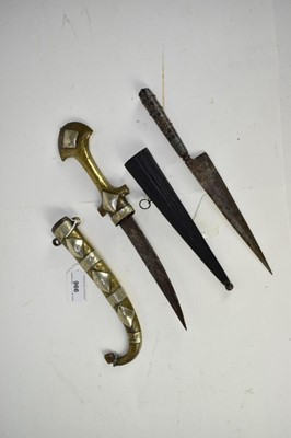 Lot 966 - 19th century Arab jambia dagger in white metal and brass sheath, another eastern dagger with coral hilt decoration in wooden sheath (2)