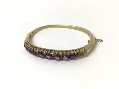 Lot 212 - Victorian style gold and amethyst hinged bangle with graduated round mixed cut amethysts and diamond accents to the claws with pierced gallery.