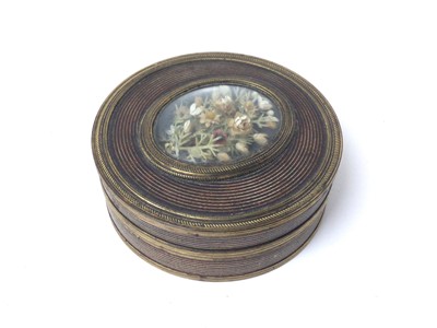 Lot 210 - Unusual Georgian red tortoishell, red lacquer and gilt metal mounted circular snuff box with cut paper floral display under double sided domed glass 7.6 cm diameter