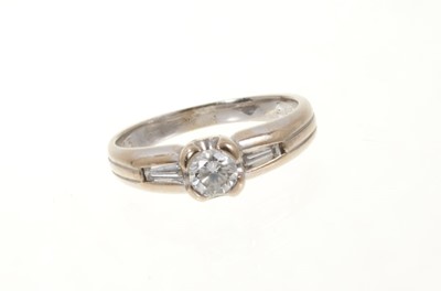 Lot 443 - Diamond single stone ring with a brilliant cut diamond flanked by two tapered baguette cut diamonds in 18ct white gold setting