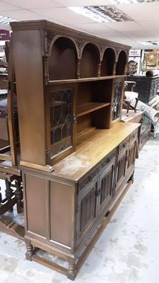Lot 1085 - Old Charm oak two height dresser with open shelves and two cupboards above enclosed by leaded glazed doors, four drawers and four linenfold panelled doors below, 184cm wide, 48.5cm deep, 183cm high
