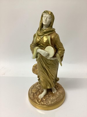 Lot 62 - An early 20th century Royal Worcester figure of a musician, modelled in gilt as a lady with a drum, signed Hadley with puce mark to base and number 1567