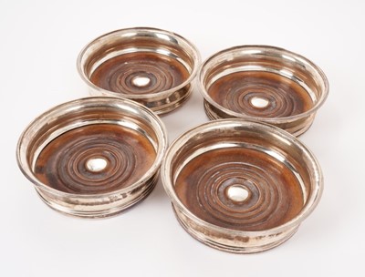 Lot 201 - Four George III silver bottle coasters