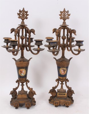 Lot 85 - Pair of 19th century Continental gilt metal and painted porcelain four branch candlesticks, with scrolling candle arms and portrait painted vase columns on stepped plinth bases, 50cm high