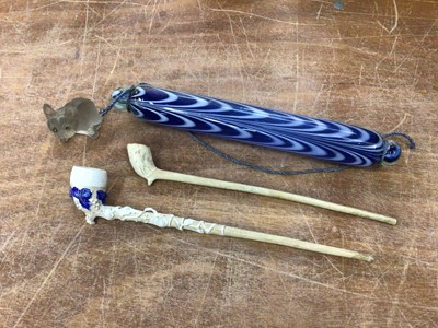 Lot 91 - Small Nailsea glass rolling pin, tiny glass seated dog and two 19th century clay pipes