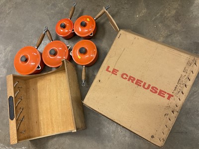Lot 182 - Graduated set of five Le Creuset lidded saucepans, with hanging shelf, boxed