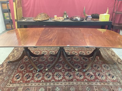 Lot 1304 - Late 19th/early 20th century Georgian-style mahogany three pedestal dining table with crossbanded top, on turned columns and reeded splayed legs terminating on brass paw feet and castors