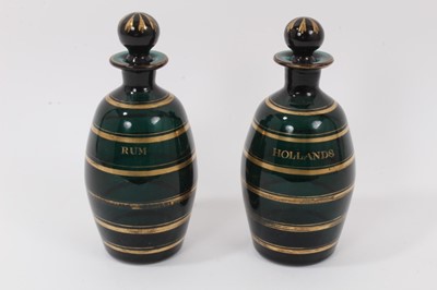 Lot 29 - A pair of early 19th century Bristol green glass ovoid-shaped decanters, decorated in gilt and labelled 'Rum' and 'Hollands', 20.5cm high
