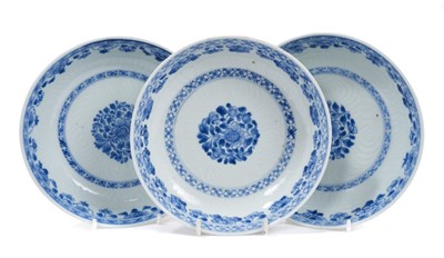 Lot 70 - Three 18th century Chinese blue and white porcelain dishes, with floral decoration and incised patterns, 16.5cm diameter