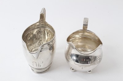 Lot 222 - Georgian silver oval form helmet-shaped jug with reeded borders, (London 1799), 11.5cm high, 4ozs and Victorian silver helmet-shaped milk jug on ball feet (marks rubbed) approx. 4.5ozs (2)
