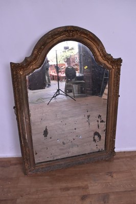 Lot 1340 - Gilt gesso wall mirror, pleasantly distressed plate of arched form, in pierced and scroll moulded frame, the frame 18th century