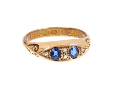Lot 402 - Edwardian sapphire and diamond ring with two oval mixed cut blue sapphires interspaced by rose cut diamonds in boat-shape gold setting with carved gold shoulders, Chester 1906. Ring size M½.