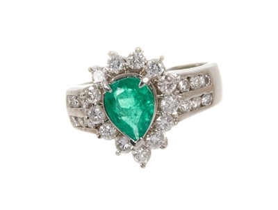 Lot 449 - Emerald and diamond cluster ring with a pear cut emerald measuring approximately 8mm x 6mm surrounded by a border of thirteen brilliant cut diamonds in claw setting flanked by twelve channel-set br...