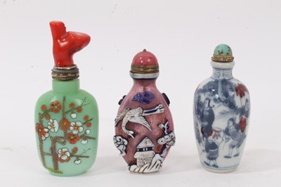 Lot 804 - Chinese Peking style overlaid glass snuff bottle, with stopper, 8.5cm high, together with a blue and white painted snuff and painted glass snuff bottle with coral capped stopper. (3)