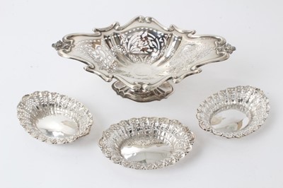 Lot 271 - Edwardian pierced silver bon bon dish on pedestal, (Chester marks rubbed) 25.5cm and set three Victorian pierced silver oval dishes, Sheffield 1895, 12cm