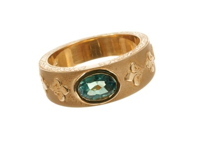 Lot 441 - Large 18ct gold ring with an oval mixed cut green stone in rub-over setting on tapered gold band with applied gold Fleur de Lys and and oak leaves, London 2007. Ring size X.