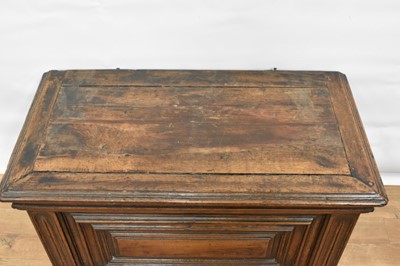 Lot 1466 - 17th century Continental oak cassone, of small size, with hinged lid and interior candle box, panelled front flanked by iron carrying handles, on stiles