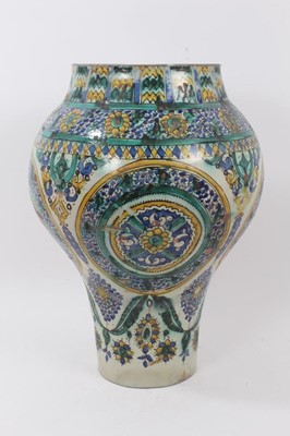 Lot 131 - A large tin glazed ceramic vase, probably 19th century Spanish, decorated with foliate patterns in yellow, green and blue, 45cm high