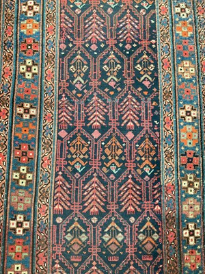Lot 1505 - Anatolian runner, with repeat foliate device on midnight blue ground, in geometric borders, 416 x 92cm