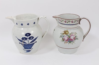 Lot 138 - Two early 19th century pearlware pottery jugs, both decorated with floral patterns, one in polychrome enamels and the other blue and white, 22cm high
