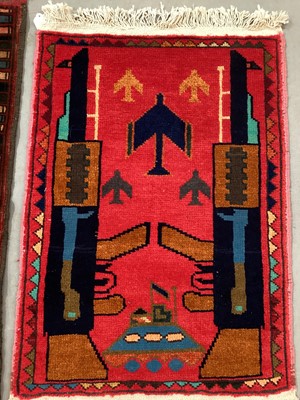 Lot 1523 - Two 1970s Afghan political rugs with war motifs, approximately 98cm x 65cm.