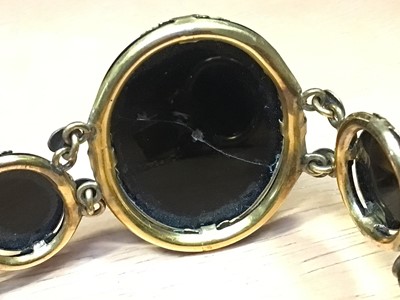 Lot 31 - Victorian black glass cameo bracelet in yellow metal setting together with a black onyx and silver brooch (2)