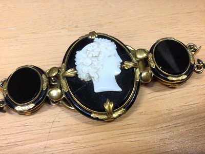 Lot 31 - Victorian black glass cameo bracelet in yellow metal setting together with a black onyx and silver brooch (2)