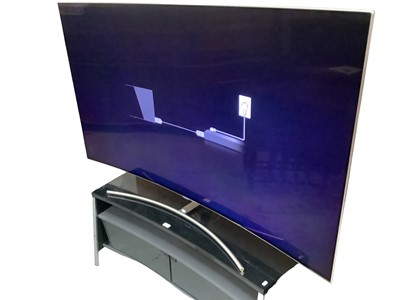 Lot 1 - 75" Qled Curved Samsung TV together with Stand and remote control. Television currently turns on but not working as it's missing it's Fibre optic lead.