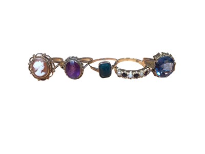 Lot 189 - Five gold rings to include a 9ct gold cameo ring in open work setting, 9ct gold oval amethyst, 9ct gold bloodstone plaque, 9ct sapphire and seed pearl seven stone ring and a blue stone yellow metal...