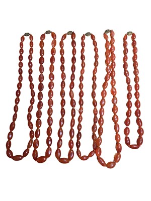 Lot 131 - Six Chinese oval carnelian bead necklaces with silver gilt clasps