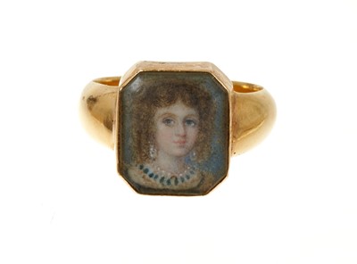 Lot 652 - An early 19th century gold portrait ring with a finely painted portrait miniature depicting a young lady, in a glazed bezel on gold shank. Ring size approximately P.