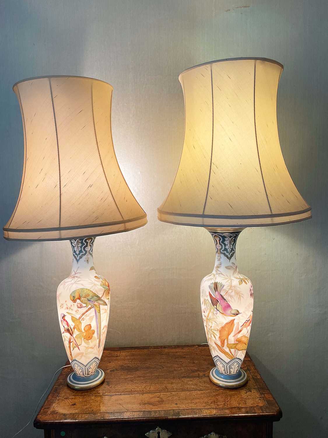 Lot 1058 - Pair of 19th century painted bohemian milk glass vases, presented as lamps, painted with exotic birds. vases 50cm high