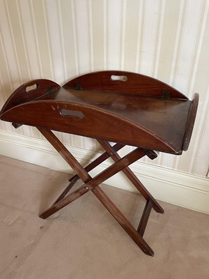 Lot 1064 - Antique mahogany butler's tray on stand, the tray with hinged sides with pierced integral carrying handles, 76 x 49cm on collapsible stand