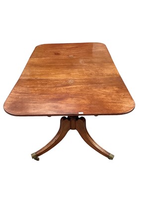 Lot 1067 - Regency mahogany twin pedestal dining table, with rounded rectangular reeded top, on turned pedestals and reeded swept tripod cabriole legs on castors, with one additional leaf, 213 x 120cm when ex...