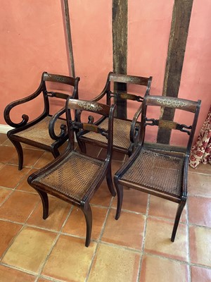 Lot 1070 - Set of four Regency rosewood and brass inlaid dining chairs, each with bar back and caned seat on reeded sabre legs, to include a pair of carvers
