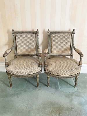Lot 1072 - Pair of Louis XVI style painted and gilt wood fauteuils, each fluted showood frame and stud closed upholstery on tapered fluted legs