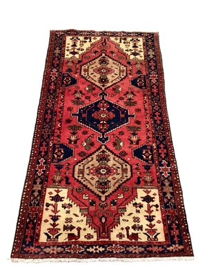 Lot 1165 - Eastern rug with three central medallions on red blue and cream ground, 197cm x 102cm