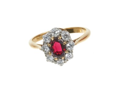 Lot 313 - Garnet and diamond cluster ring with an oval mixed cut garnet surrounded by 
eight brilliant cut diamonds in platinum claw setting 18ct yellow gold shank