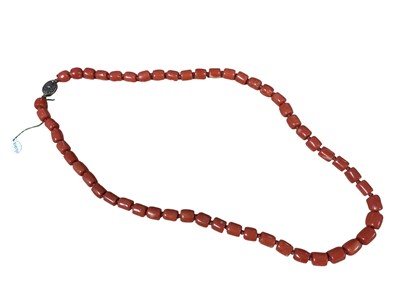 Lot 6 - Old Chinese coral necklace with barrel shaped polished beads and oval silver gilt clasp with wire work flower decoration, 64.5cm long